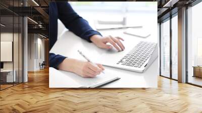 young woman using laptop for searching information in internet at table Wall mural