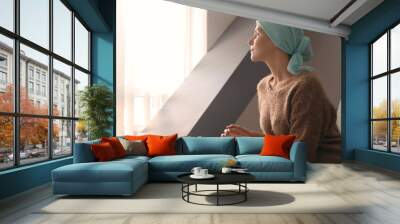 Young woman with cancer in headscarf indoors Wall mural