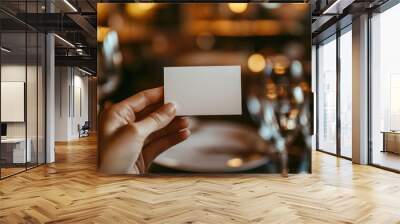 Hand holding a blank white card at a luxury restaurant Wall mural