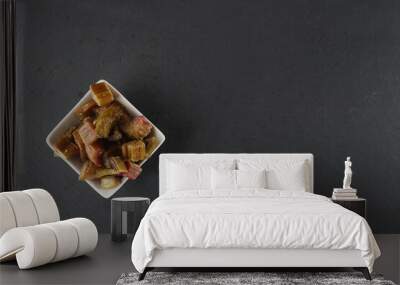 white bowl of candied rheum isolated on black background flat lay Wall mural