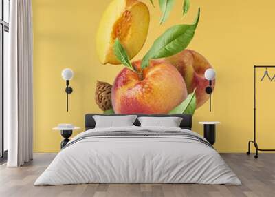 Flying fresh ripe peach with green leaves isolated Wall mural