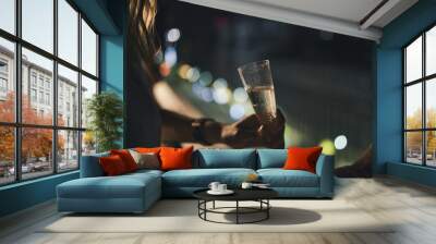 gril with a glass of champagne with city lights background Wall mural