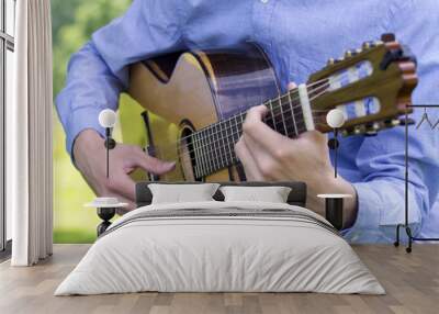 Young male playing a classic guitar outside Wall mural