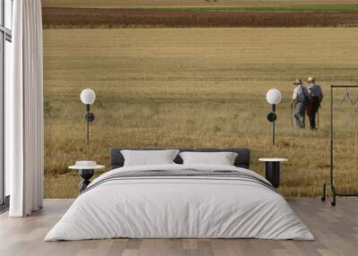 Two old men strolling in the field in a wheat threshing floor Wall mural