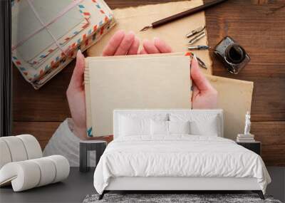 Young woman holds an envelope and blank sheet of paper Wall mural