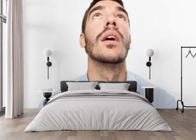 Close up of an astonished young man looking up Wall mural