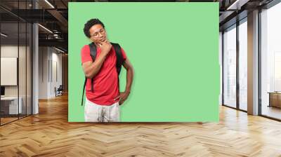 Happy young man making a gesture of doubt Wall mural