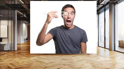 Surprised young man eating sushi Wall mural