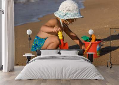 little girl in the bonnet plaing with sand, childhood Wall mural