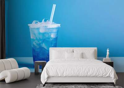 Blue drink in a plastic cup isolated on a blue background. Take away drinks concept with copy space Wall mural