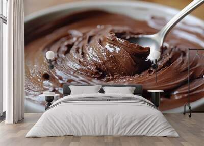 A close-up of creamy chocolate spread in a bowl with a spoon. Wall mural