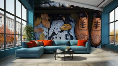 A pair of stylish brown shoes on a textured surface with autumn leaves. Wall mural