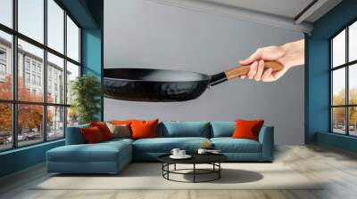 Side view of man holding frying pan Wall mural