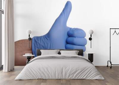 thumb up hand gesture in blue nitrile glove. nitrile gloved hand shows thumb up success gesture. pho Wall mural