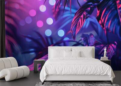 A leafy green plant with purple and blue lights shining on it Wall mural