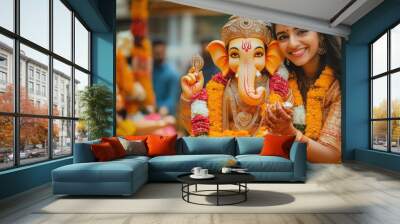 A young Indian couple holding a Lord Ganesha sculpture, joyfully celebrating the Ganesha festival with traditional attire and vibrant decor  Wall mural