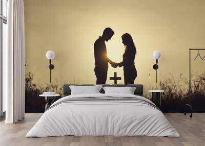 Silhouette of a couple clasping hands, with an Easter cross framed between them, representing love and unity in the context of Good Friday observance  Wall mural