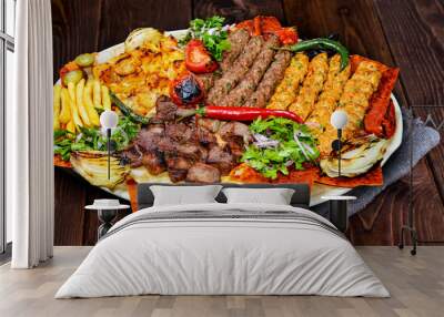 Shish kebab on a stick, from ground beef meat. Lula kebab, traditional Caucasian dish. On the black background of the concrete, on a chopping board, with ketchup, spices and tomatoes copy space above Wall mural