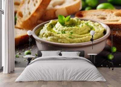 Bowl of tasty hummus with fresh green peas and bread on table Wall mural