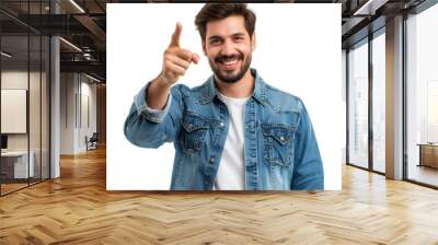 A man wearing jeans over a white t-shirt is smiling and pointing his finger upwards. Wall mural