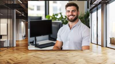 Smiling male entrepreneur in casual attire working at a standing desk with dual monitors contemporary office design  Wall mural