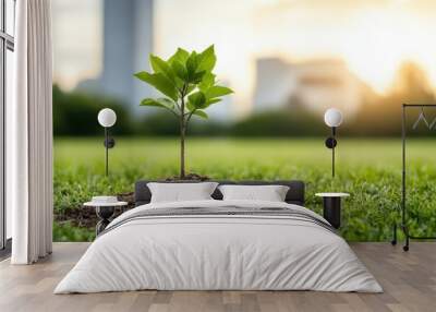 A young sapling emerging from rich soil, symbolizing growth and sustainability in a lush green landscape. Wall mural