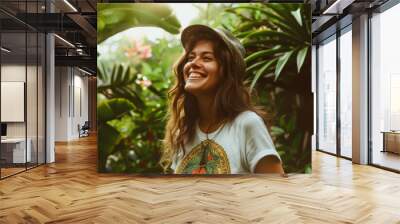 A young woman, glowing with joy, stands amidst lush tropical plants, her smile as bright as the morning sun. Wall mural