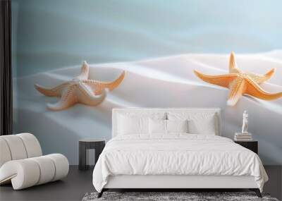 Two starfish gently resting on smooth, wind-rippled sand, capturing the essence of a tranquil and untouched seaside moment. Wall mural