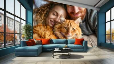 Happy young couple holding cute cat. Home cozy togetherness. Wall mural