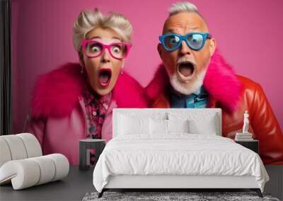 A Playful Elderly Couple wearing Sunglasses and Colourful Mismatched Clothing. A man and woman wearing  sunglasses and fun multicoloured clothing Wall mural