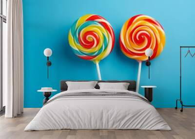 Photo of two colourful lollipops  together on a plain blue background created with Generative AI technology Wall mural