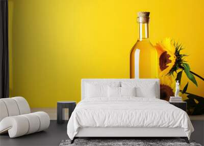 A bottle of sunflower oil and sunflower on yellow background. Wall mural