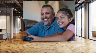 A Hispanic father and daughter have a blast playing video games together in the living room of their home. Their faces light up with happiness as they engage in friendly competition and cooperation, Wall mural