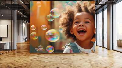 An African American child blowing bubbles and laughing with joy against a colorful background Wall mural