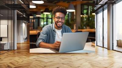 Happy African Black guy student using laptop computer in university library Wall mural