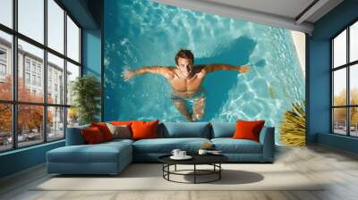 Young man relaxing in resort swimming pool. Top view Wall mural