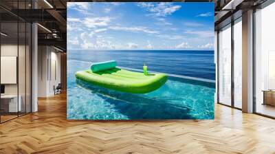 A luxurious, infinity-edge swimming pool overlooking the ocean. A neon-green air mattress with a tropical drink holder floats in the serene water, with the horizon blending into the sky. Gentle waves Wall mural