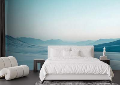 A serene snow-covered landscape with a gradient sky transitioning from a pale blue at the horizon to a deep indigo above. The snow-covered ground and distant mountains are bathed in the cool gradient Wall mural