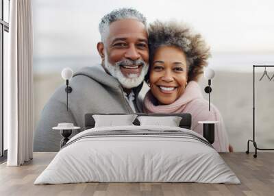 Very happy African American mature woman embracing retired man at beach Wall mural