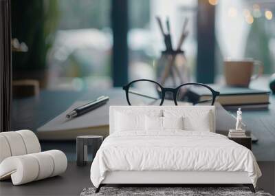 Workstation setup with notebook pen paper and glasses on gray surface for idea generation and writing in home office Wall mural