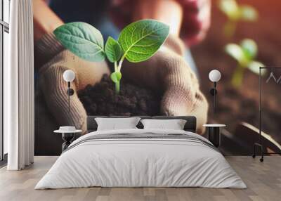 A woman farmer cradles a vibrant green seedling flourishing in the rich soil. Wall mural