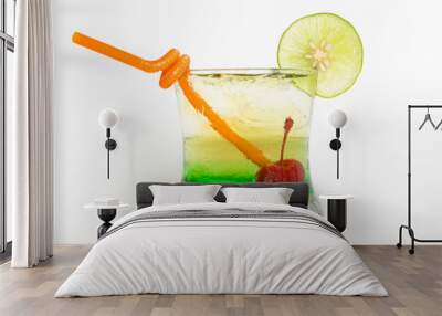 a green cocktail with a cherry in a glass decorated with sliced lime and straw Wall mural