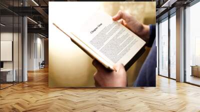 man's hand on book page with title 