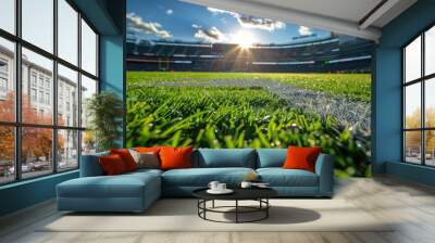 A vibrant, close-up view of the dewy grass field of a football stadium, bathed in sunlight as the day begins, with the stands in the background Wall mural