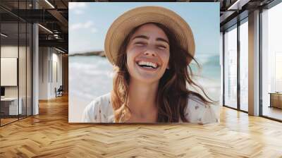 Happy woman with hat smiling and laughing standing outside at the beach on a sunny day - Beautiful young female enjoy nature relaxing outdoors - Happy lifestyle and healthcare concept  Wall mural