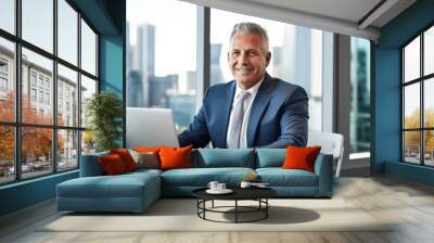 A middle-aged businessman in a suit and tie, working at a modern office desk with a laptop. The city skyline can be seen through the window. Professional, successful, and focused on his career Wall mural