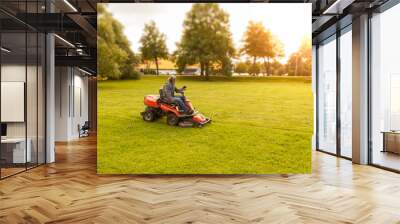 lawn mower tractor working in the town park Wall mural