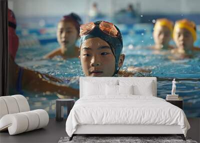 A group of Asian young swimmers in an indoor pool during a swimming lesson. Wall mural