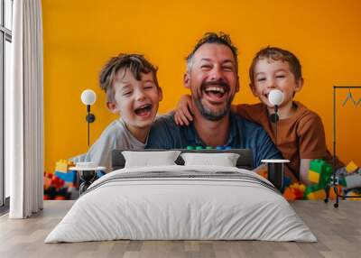 A father and his two sons beam with joy as they play indoors, their faces lighting up as they build a colorful lego wall together Wall mural