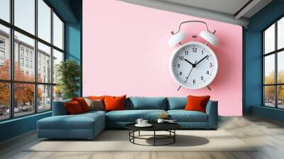 An alarm clock on a pastel pink background. Wall mural